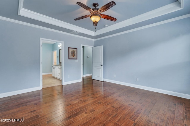 spare room with hardwood / wood-style flooring, ceiling fan, ornamental molding, and a tray ceiling