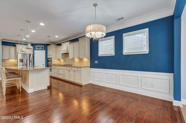 kitchen featuring custom exhaust hood, tasteful backsplash, a kitchen breakfast bar, pendant lighting, and stainless steel appliances