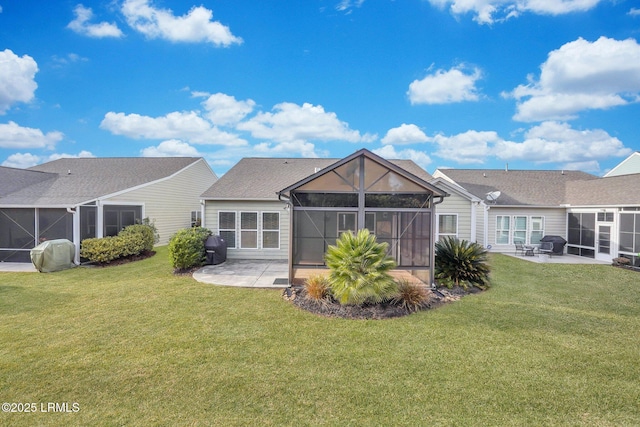 back of house with a patio, glass enclosure, and a lawn