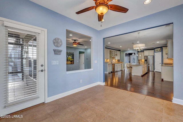 interior space with sink, ceiling fan with notable chandelier, and tile patterned floors