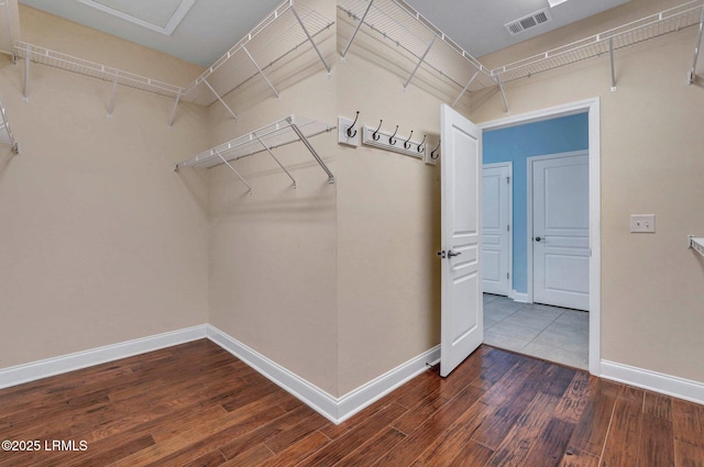 walk in closet with dark hardwood / wood-style flooring