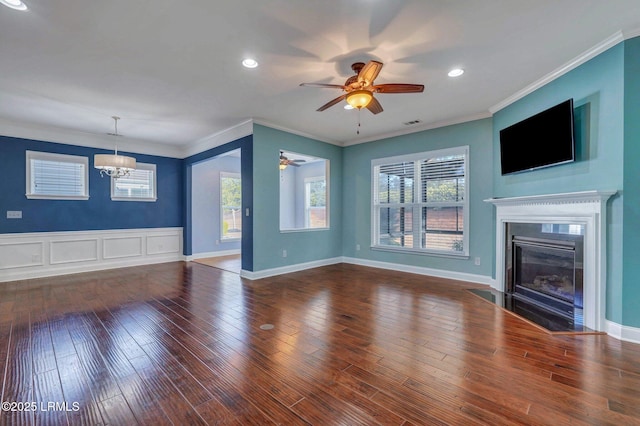 unfurnished living room with crown molding, hardwood / wood-style flooring, and ceiling fan with notable chandelier