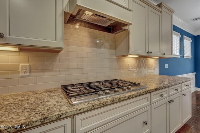 kitchen featuring ornamental molding, dark hardwood / wood-style flooring, custom range hood, stainless steel gas stovetop, and light stone countertops