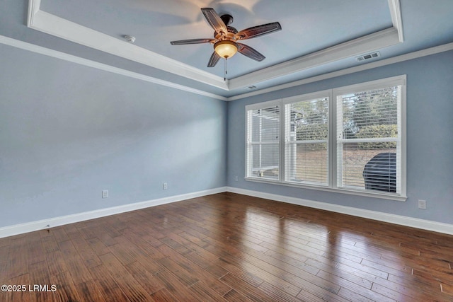 empty room featuring ceiling fan, ornamental molding, dark hardwood / wood-style floors, and a raised ceiling