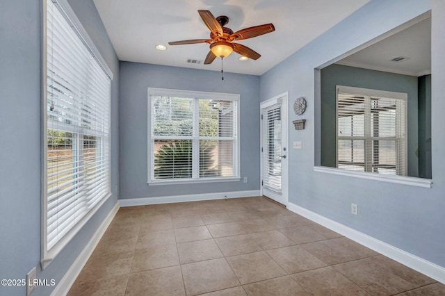 tiled spare room featuring ceiling fan