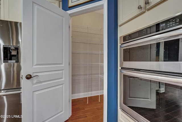 interior space with appliances with stainless steel finishes and hardwood / wood-style floors