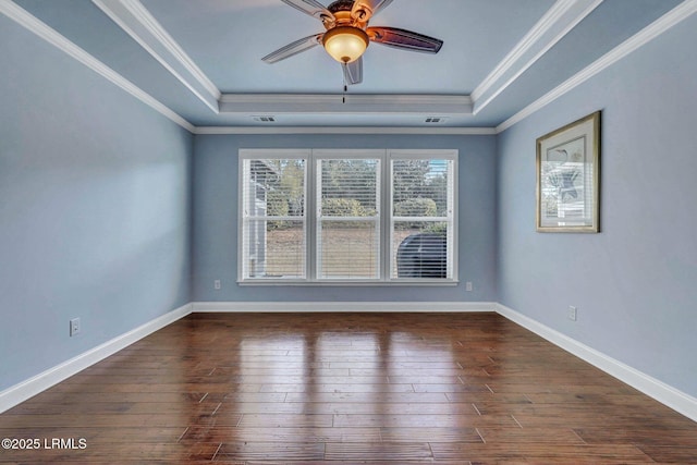 spare room with crown molding, ceiling fan, dark hardwood / wood-style flooring, and a tray ceiling