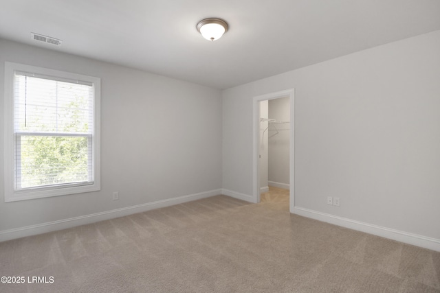 587 Hulston Landing Rd, Bluffton, SC 29909 - unfurnished bedroom featuring light colored carpet, multiple windows, a walk in closet, and a closet