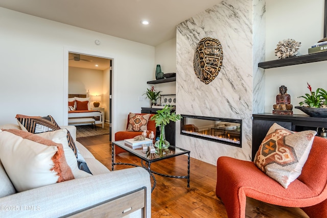 living area with hardwood / wood-style flooring, recessed lighting, and a high end fireplace