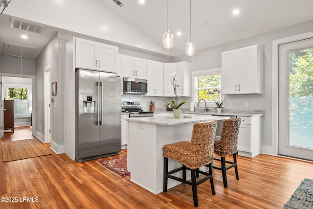 1 William St, Beaufort, SC 29907 - kitchen with lofted ceiling, light wood-style flooring, visible vents, white cabinetry, and appliances with stainless steel finishes