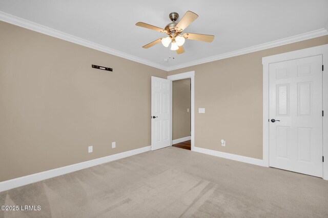 unfurnished bedroom featuring baseboards, ornamental molding, a ceiling fan, and light colored carpet
