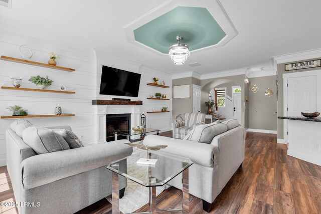 living area featuring crown molding, a fireplace, arched walkways, baseboards, and dark wood-style floors