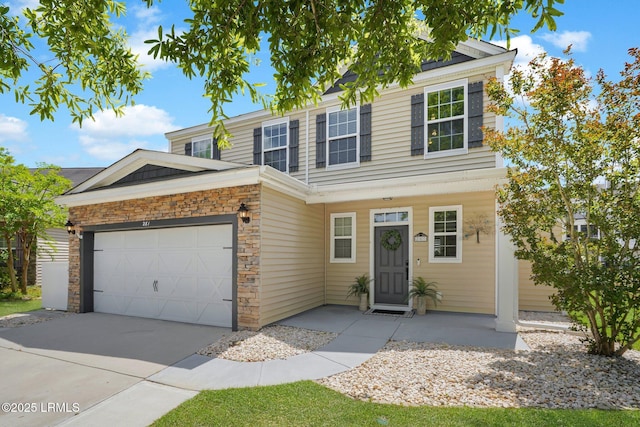 traditional-style house with an attached garage, concrete driveway, and stone siding