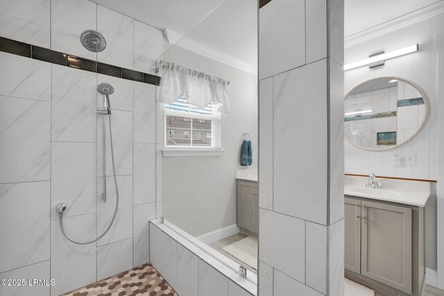 full bath featuring vanity, ornamental molding, and a tile shower