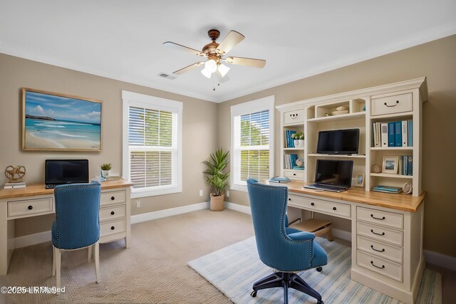 office featuring visible vents, light carpet, baseboards, built in study area, and a ceiling fan
