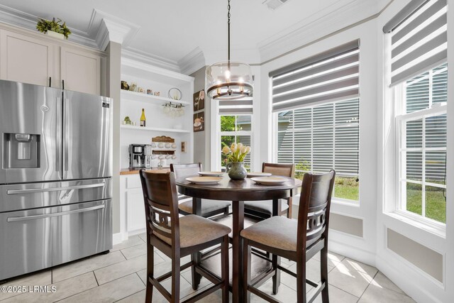dining space with crown molding, light tile patterned flooring, a notable chandelier, and visible vents