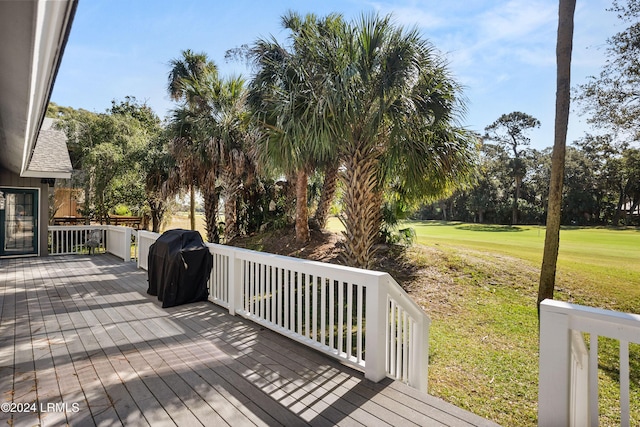 wooden deck with area for grilling and a yard