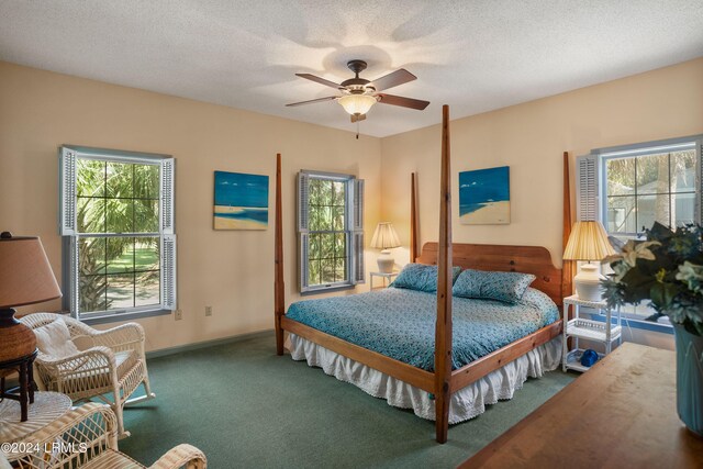 bedroom with dark carpet, a textured ceiling, and ceiling fan