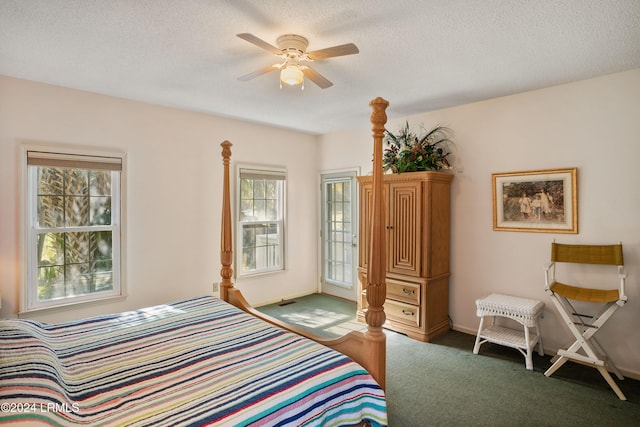 bedroom with a textured ceiling, ceiling fan, and dark colored carpet