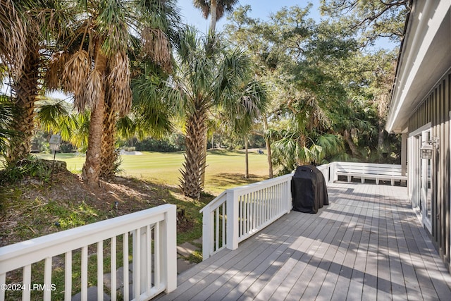 wooden terrace featuring a lawn