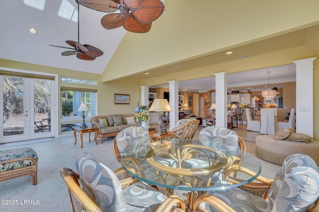 tiled dining room featuring decorative columns, high vaulted ceiling, and ceiling fan