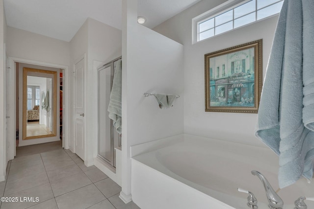 bathroom with tile patterned flooring, independent shower and bath, and a wealth of natural light