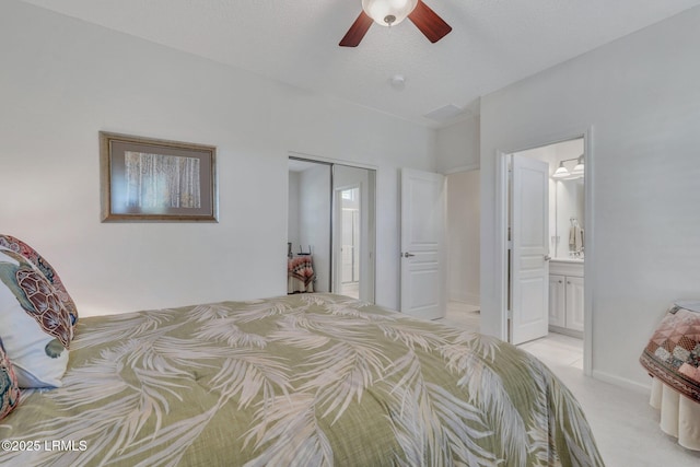 bedroom featuring ceiling fan, light colored carpet, ensuite bathroom, and a textured ceiling