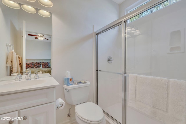 bathroom featuring sink, an enclosed shower, ceiling fan, and toilet