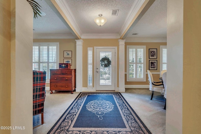 carpeted entryway featuring decorative columns, ornamental molding, plenty of natural light, and a textured ceiling