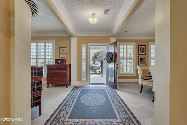 foyer entrance featuring light colored carpet, plenty of natural light, and ornate columns