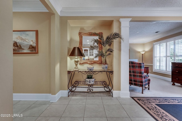 corridor with tile patterned flooring, ornamental molding, decorative columns, and a textured ceiling