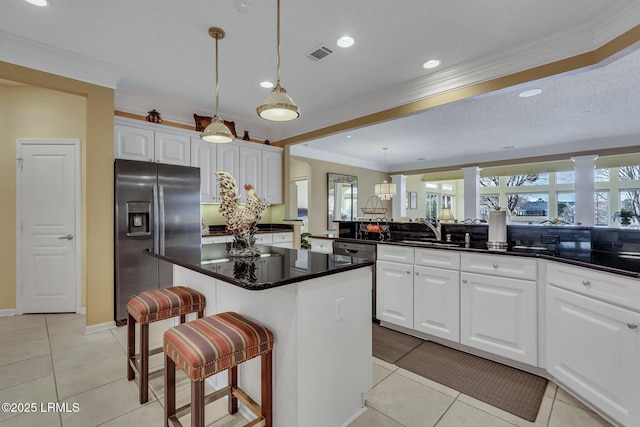 kitchen featuring sink, white cabinetry, a kitchen breakfast bar, a center island, and stainless steel refrigerator with ice dispenser