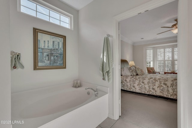 bathroom featuring crown molding, tile patterned floors, ceiling fan, and a bathtub