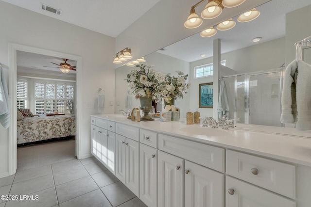 bathroom with ceiling fan, vanity, a shower with door, and tile patterned flooring