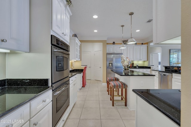 kitchen featuring decorative light fixtures, light tile patterned flooring, white cabinets, and appliances with stainless steel finishes