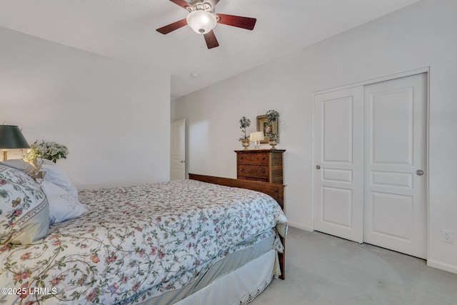 carpeted bedroom with ceiling fan and a closet