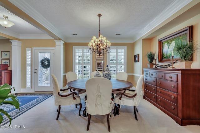 carpeted dining area featuring ornate columns, crown molding, and a textured ceiling