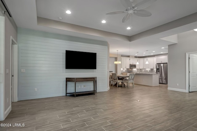 living room featuring ceiling fan and a barn door