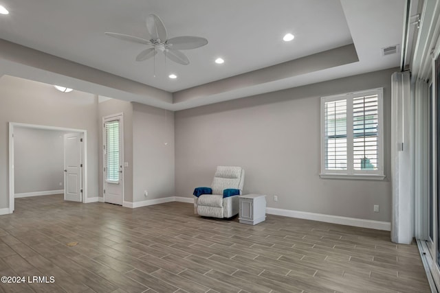 unfurnished room with ceiling fan and a tray ceiling