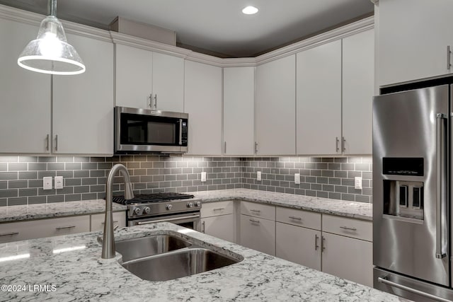 kitchen featuring white cabinetry, appliances with stainless steel finishes, light stone counters, and decorative backsplash