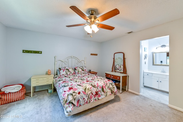 carpeted bedroom featuring ensuite bathroom, sink, and ceiling fan