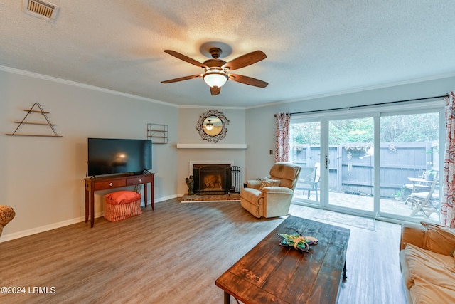 living room with hardwood / wood-style flooring, crown molding, and a textured ceiling