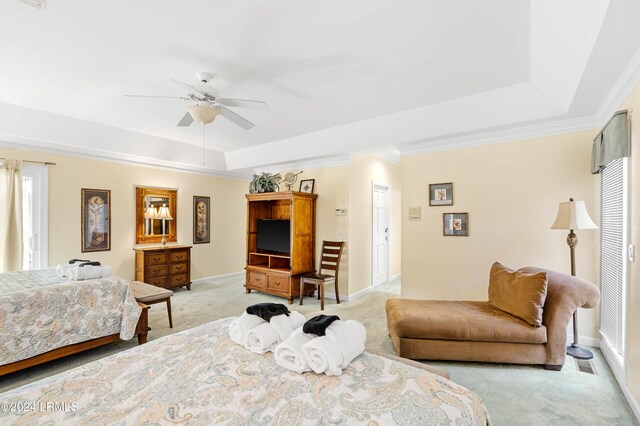 carpeted bedroom with crown molding, ceiling fan, and a tray ceiling