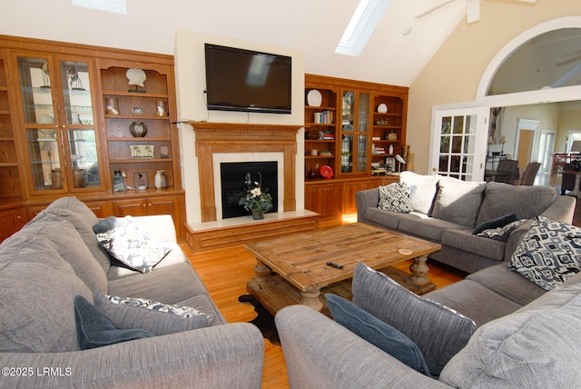 101 Ocean Point Dr, Fripp Island, SC 29920 - living room featuring ceiling fan, high vaulted ceiling, a skylight, a fireplace with raised hearth, and wood finished floors