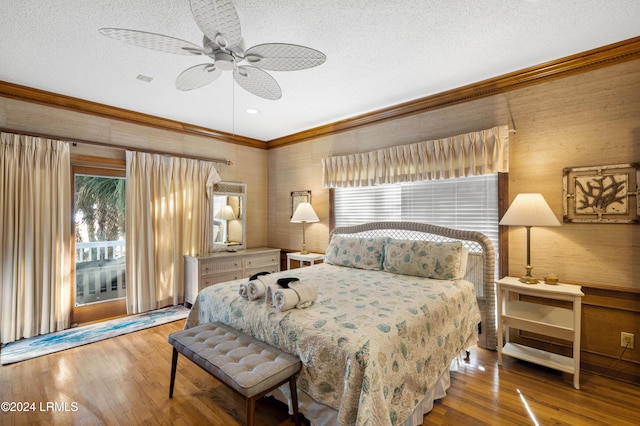 bedroom featuring crown molding, hardwood / wood-style floors, multiple windows, and a textured ceiling