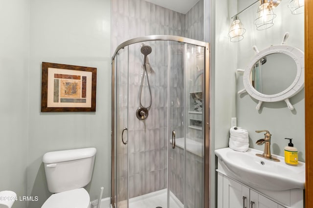 bathroom featuring vanity, an enclosed shower, and toilet