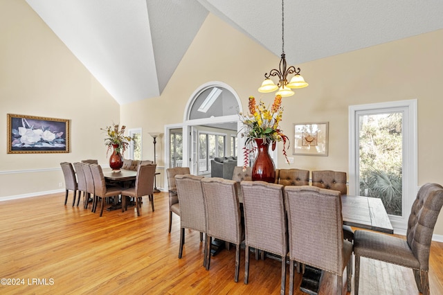 101 Ocean Point Dr, Fripp Island, SC 29920 - dining area featuring a chandelier, light wood-type flooring, plenty of natural light, high vaulted ceiling, and baseboards