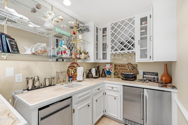 bar featuring white cabinetry, appliances with stainless steel finishes, and sink