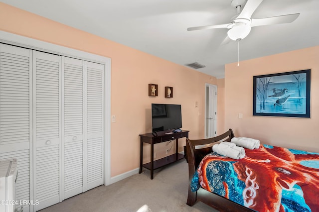 bedroom with light carpet, ceiling fan, and a closet