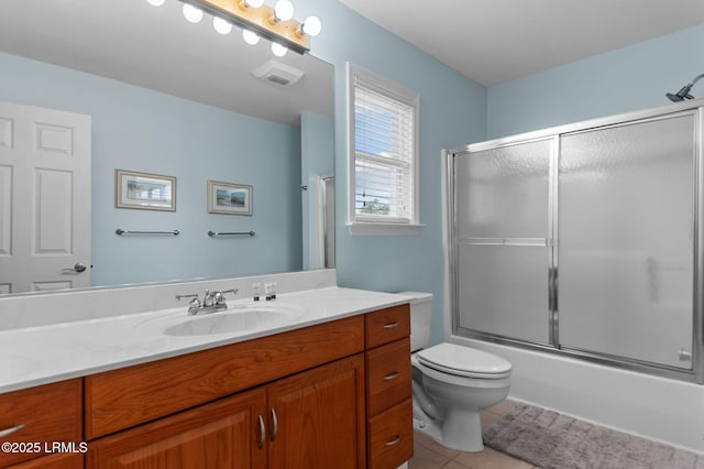 full bathroom featuring vanity, tile patterned flooring, toilet, and shower / bath combination with glass door